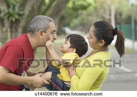 Side profile of a mid adult couple playing with their son View Large Photo Image Stock Photograph - Side profile of a mid adult couple playing with their son. Fotosearch