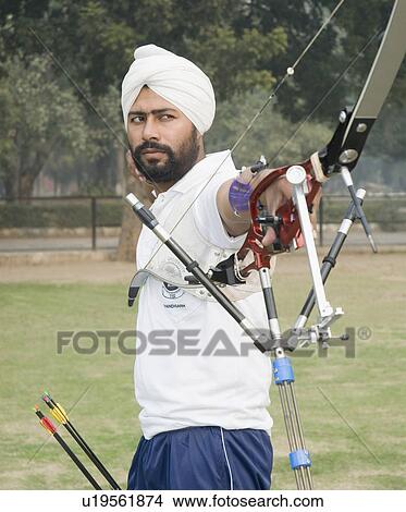 Picture - Side profile of a young man holding a bow. Fotosearch
