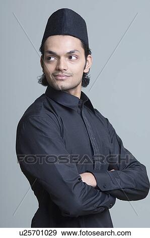 Stock Photo - Side profile of a young man with his arms crossed. Fotosearch