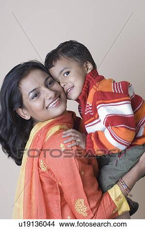 Picture - Side profile of a young woman carrying her son. Fotosearch