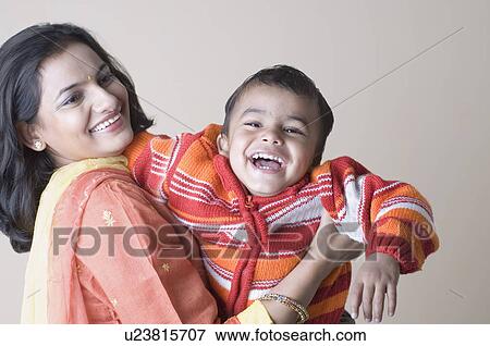 Side profile of a young woman carrying her son View Large Photo Image Stock Photo - Side profile of a young woman carrying her son. Fotosearch