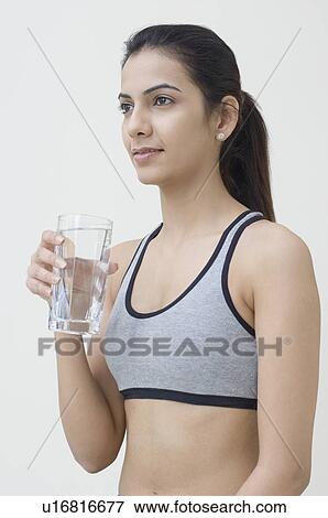 Stock Photo - Side profile of a young woman holding a glass of water. Fotosearch