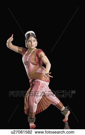 Stock Image - Side profile of a young woman performing Bharatnatyam. Fotosearch