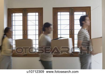 Side profile of two men and a woman carrying cardboard boxes View Large Photo Image Stock Photo - Side profile of two men and a woman carrying cardboard boxes. Fotosearch