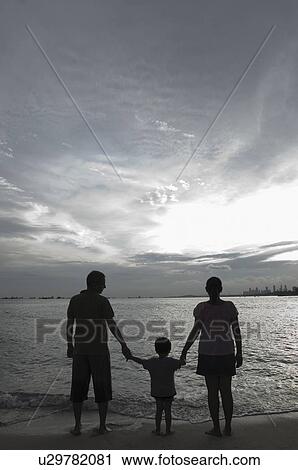 Silhouette of a couple with their son on the beach View Large Photo Image Stock Image - Silhouette of a couple with their son on the beach. Fotosearch