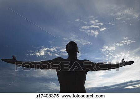 Stock Photography - Silhouette of a man standing with his arms outstretched. Fotosearch