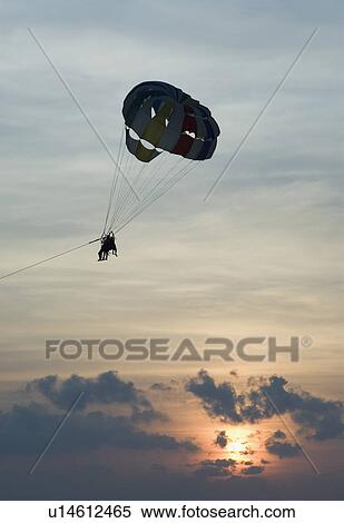Stock Photography - Silhouette of a person parasailing in the sky, Calangute Beach, Goa, India. Fotosearch