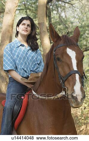 Stock Photo - Teenage girl riding a horse. Fotosearch
