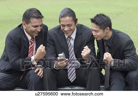 Stock Image - Three businessmen making a fist in excitement. Fotosearch