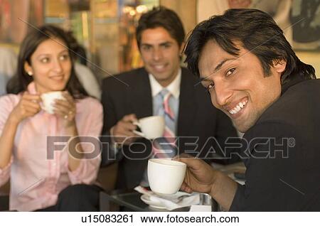 Two businessmen and a businesswoman holding coffee cups View Large Photo Image Stock Image - Two businessmen and a businesswoman holding coffee cups. Fotosearch