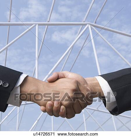 Stock Image - Two businessmen shaking hands. Fotosearch