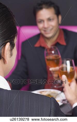 Two businessmen toasting with wine glasses View Large Photo Image Stock Photo - Two businessmen toasting with wine glasses. Fotosearch