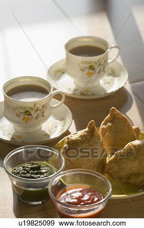 Two cups of tea served with Indian snacks and condiments View Large Photo Image Stock Photo - Two cups of tea served with Indian snacks and condiments. Fotosearch