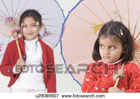 Two girls holding parasols View Large Photo Image Stock Photo - Two girls holding parasols. Fotosearch