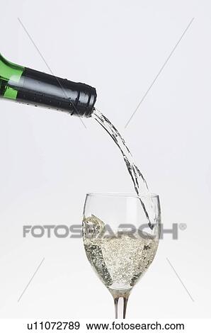Wine pouring from a bottle into a glass View Large Photo Image Stock Photo - Wine pouring from a bottle into a glass. Fotosearch