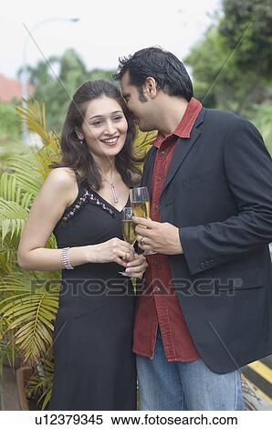 Young couple holding champagne flutes View Large Photo Image Stock Photography - Young couple holding champagne flutes. Fotosearch