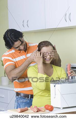 Young man covering a young woman's eyes with his hands View Large Photo Image Stock Image - Young man covering a young woman's eyes with his hands. Fotosearch