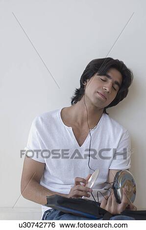 Stock Photograph - Young man listening to music. Fotosearch