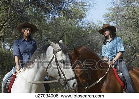 Young woman and a teenage girl riding horses View Large Photo Image Stock Photograph - Young woman and a teenage girl riding horses. Fotosearch