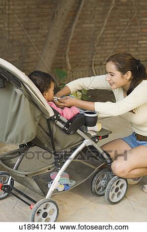 Picture - Young woman looking at her baby and smiling. Fotosearch