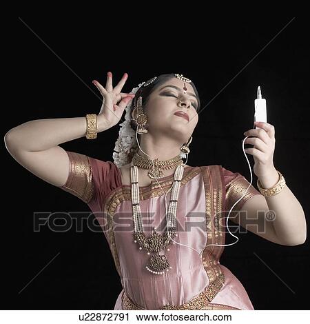 Young woman performing Bharatnatyam and listening to an MP3 player View Large Photo Image Stock Image - Young woman performing Bharatnatyam and listening to an MP3 player. Fotosearch