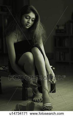 Young woman putting on a sandal View Large Photo Image Stock Image - Young woman putting on a sandal. Fotosearch