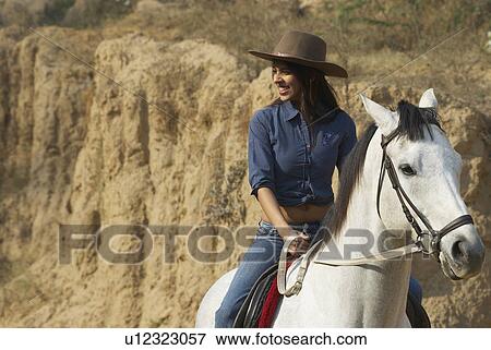 Young woman riding a horse and smiling View Large Photo Image Stock Photo - Young woman riding a horse and smiling. Fotosearch