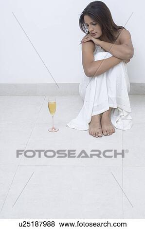 Young woman sitting on the floor beside a champagne flute View Large Photo Image Stock Photo - Young woman sitting on the floor beside a champagne flute. Fotosearch
