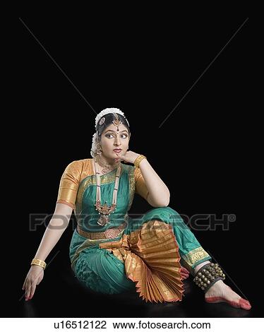Young woman sitting with her hand on her chin View Large Photo Image Stock Image - Young woman sitting with her hand on her chin. Fotosearch