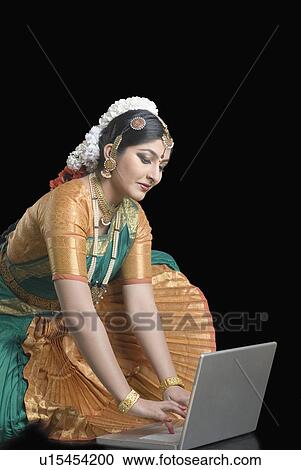 Stock Image - Young woman using a laptop. Fotosearch