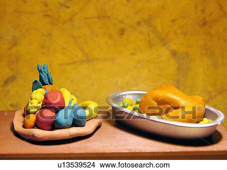 Picture - A plate of fruit and a chicken roast. Fotosearch