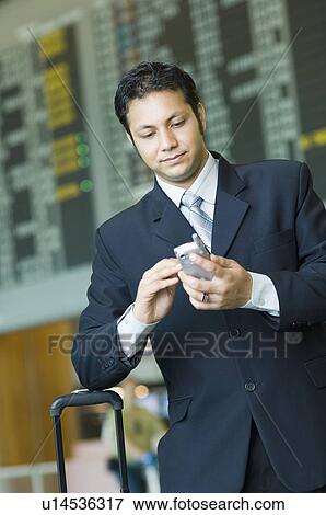 Businessman holding a mobile phone View Large Photo Image Stock Photo - Businessman holding a mobile phone. Fotosearch