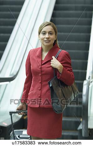 Businesswoman pulling her luggage and smiling View Large Photo Image Stock Image - Businesswoman pulling her luggage and smiling. Fotosearch