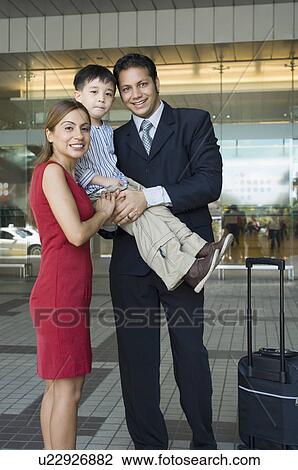 Stock Image - Portrait of a businessman with his son and wife at an airport. Fotosearch