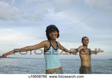 Portrait of a young couple holding hands on the beach and smiling View Large Photo Image Stock Photograph - Portrait of a young couple holding hands on the beach and smiling. Fotosearch