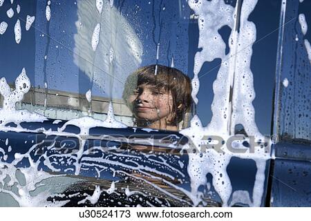 Stock Image - Boys reflection in a window of a car. Fotosearch