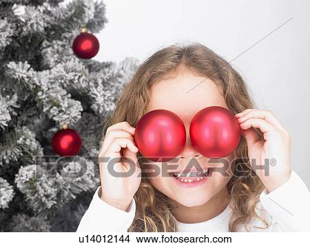 Picture - Girl playing with Christmas decoration. Fotosearch