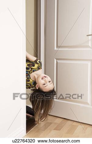 Girl poking her head round a door View Large Photo Image Stock Image - Girl poking her head round a door. Fotosearch