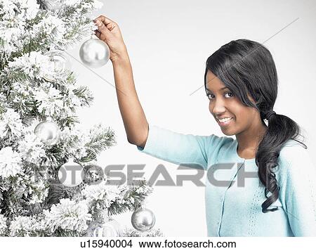 Picture - Woman hanging Christmas decoration. Fotosearch