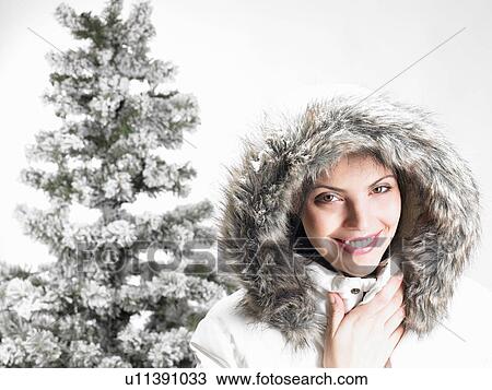 Woman next to a fir-tree, smiling View Large Photo Image Stock Image - Woman next to a fir-tree, smiling. Fotosearch