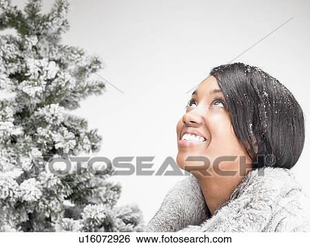 woman next to a fir-tree, smiling View Large Photo Image Stock Photograph - woman next to a fir-tree, smiling. Fotosearch
