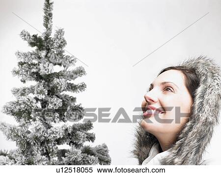 Woman next to a fir-tree, smiling View Large Photo Image Stock Photography - Woman next to a fir-tree, smiling. Fotosearch