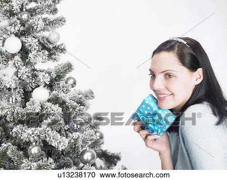 Woman next to a fir-tree, with present View Large Photo Image Stock Image - Woman next to a fir-tree, with present. Fotosearch
