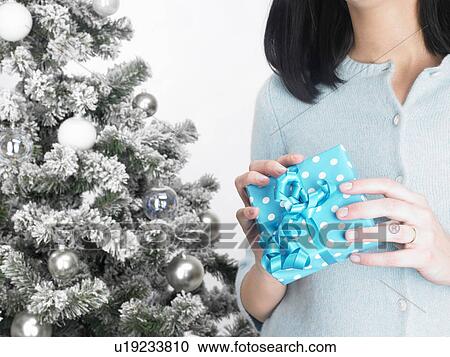 Woman next to a fir-tree, with present View Large Photo Image Stock Image - Woman next to a fir-tree, with present. Fotosearch