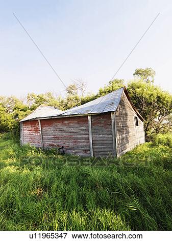 Abandoned wooden barn in state of disrepair in lush field View Large Photo Image Stock Photo - Abandoned wooden barn in state of disrepair in lush field. Fotosearch