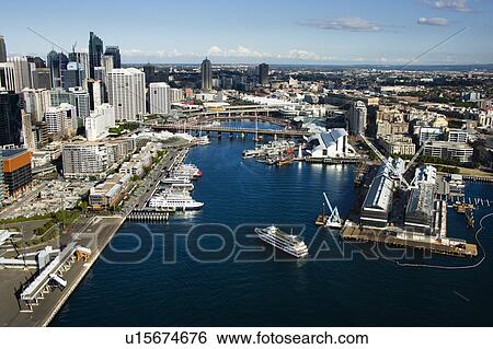 Stock Photograph - Aerial view of ships and boats in Darling Harbour with view of skyscrapers in Sydney, Australia. Fotosearch