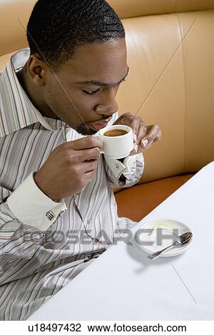 Stock Image - African American mid adult man drinking expresso.. Fotosearch