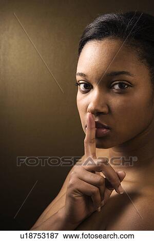 African-American young adult female shushing the viewer. View Large Photo Image Stock Photo - African-American young adult female shushing the viewer.. Fotosearch
