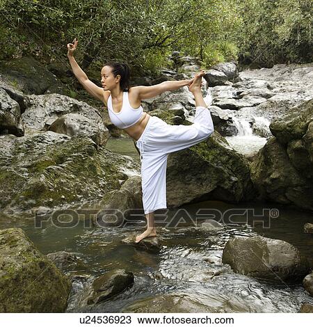 Asian American woman doing yoga balancing on boulder by creek in Maui, Hawaii. View Large Photo Image Stock Image - Asian American woman doing yoga balancing on boulder by creek in Maui, Hawaii.. Fotosearch