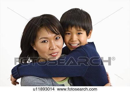 Picture - Asian mother and son hugging and smiling.. Fotosearch